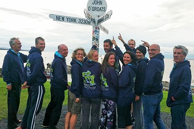 Team pointing at John O'Groats finger post