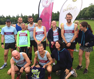 Group standing in front of Farnham Runners and Parkrun flags at Inverness parkrun