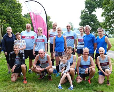 Group in front of Farnham Runners flag at Bodmin parkrun