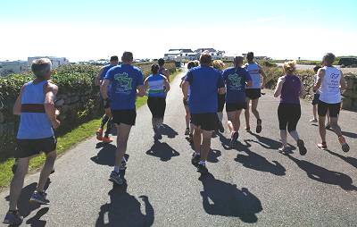 Runners approaching buildings at Land's End