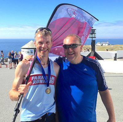 Ian Carley and Richard Sheppherd with Farnham Runners flag at Lands End