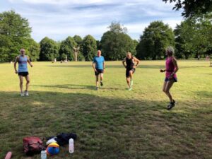 Runners warming up for Covid speed training session in Farnham Park