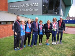 Group with medals back in Farnham after the 2019 London Marathon