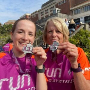 Sally Kerr with her daughter posing with their medals after the 2021 Bournemouth Half Marathon