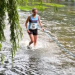 Emma Patton crosses the River Wey during the 2022 Elstead Marathon