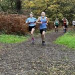 Louise Granell and Chris Raby running in the 2022-23 SXCL Bourne Woods cross-country in Farnham