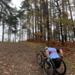 Rachel Morris in her wheelchair powering up one of the steep hills in the 2022-23 SXCL Bourne Woods cross-country in Farnham