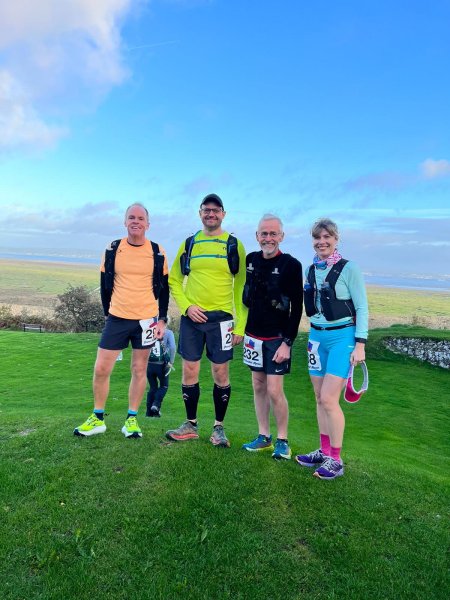 Justin Clarke, Ivan Chunnett, Chris Raby and Louise Granell posing near the finish of the the 2022 Gower Runs