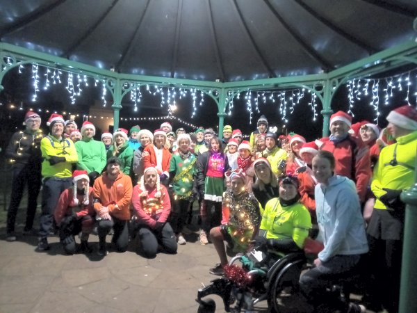 Farnham Runners in fancy dress gathering in the bandstand in Gostrey Meadow for the 2022 Mince Pie Run