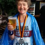 Linda Tyler after the 2017 Berlin Marathon with her medal and holding a beer