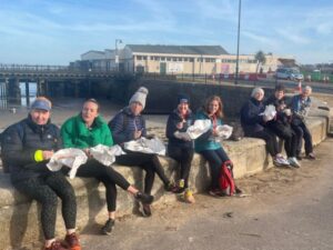 Group the Farnham Runners sitting on the sea wall in Ryde enjoying fish and chips after the 2023 Ryde 10