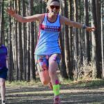 Gemma Whitehouse running the the woods at the 2024-25 SXCL Bourne Green cross-country