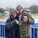 Linda and Jonathan Tyler posing with medals and a hot drink after the 2025 Arundel trail 15 miles