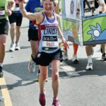 Linda Tyler waving to supporters as she is running the 2025 London Marathon