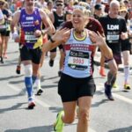 Emma Dawson waving to supporters as she is running the 2025 London Marathon