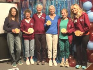 Jane Georghiou presenting the ladies Grand Prix winners with trophies at the 2025 Farnham Runners AGM and awards evening