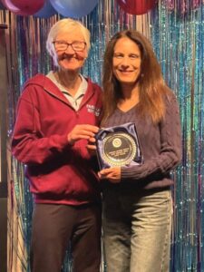 Candy Waller receiving the ladies' award for the most personal bests from Jane Georghiou at the 2025 Farnham Runners AGM and awards evening