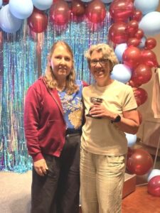 Jackie Wilkinson receiving the new Alson Yearsley trophy from Nicola O'Connor at the 2025 Farnham Runners AGM and awards evening