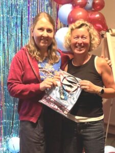 Leza Milligan receiving the Smiley Award from Nicola O'Connor at the 2025 Farnham Runners AGM and awards evening