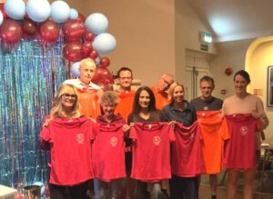 Group of members who received T shirts for those who had completed all 5 of the cross country races at the 2025 Farnham Runners AGM and awards evening