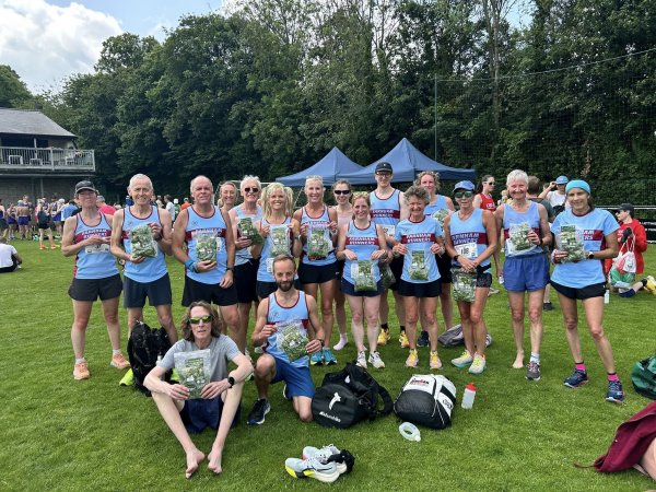 Farnham Runners team posing with the packets of watercress given to participants at the 2025 HRRL Alresford 10k