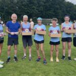 Group of the seven prize winners from Farnham Runners at the 2025 HRRL Alresford 10k (left to right Kay Copeland, Chris Raby, Jane Georghiou, Candy Waller, Linda Tyler, Gabi Hitchcock, Robert Drummond)