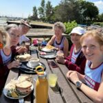 Group of Farnham Runners ladies enjoying lunch in the sunshine by the river Hamble after the 2025 Netley 10k race