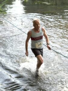 Charles Ashby crossing the River Wey at the 2025 Elstead marathon