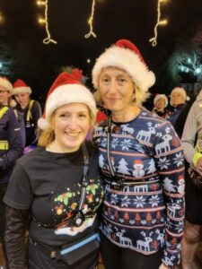 Colette Grist (left) and Kelly Lincoln wearing Christmas hats at the 2025 Mince Pie run