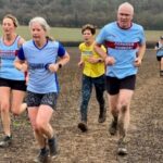 Farnham Runners Kelly Lincoln and Chris Gill running up the final hill of the 2025 SXCL Lord Wandsworth cross-country race