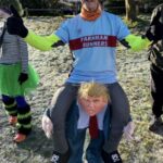 Howard Inns in a fancy dress costume that has him sitting on the shoulders of Donald Trump at the 2025 Club Handicap race