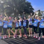 Farnham Runners ladies posing in front of a palm tree before the HRRL 2026 Ryde 10