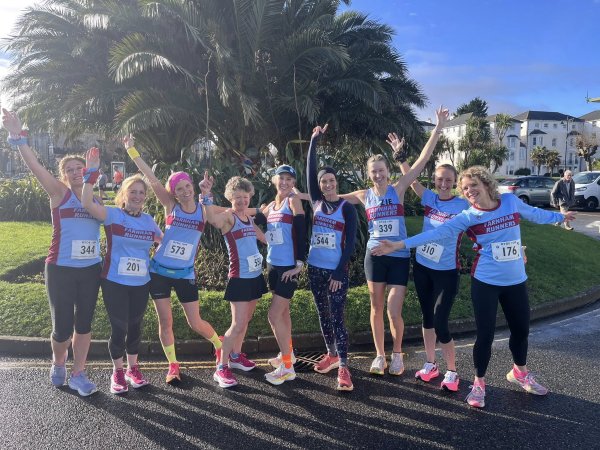 Farnham Runners ladies posing in front of a palm tree before the HRRL 2026 Ryde 10